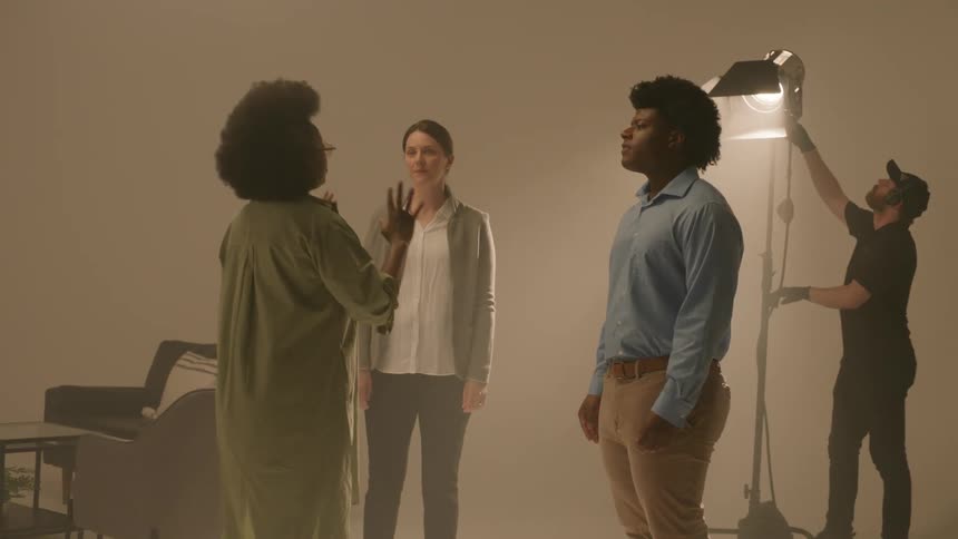 Group of men and women inside a studio clapping hands and talking