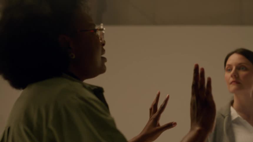 In a studio a man and woman look at each other when a screenwriter stops to give an explanation