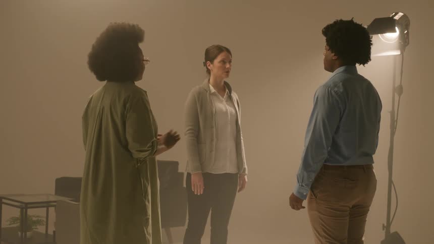 A clip of three people in a room during a therapy session