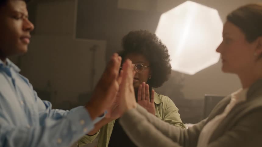 A director guiding two models to pose in front of each other