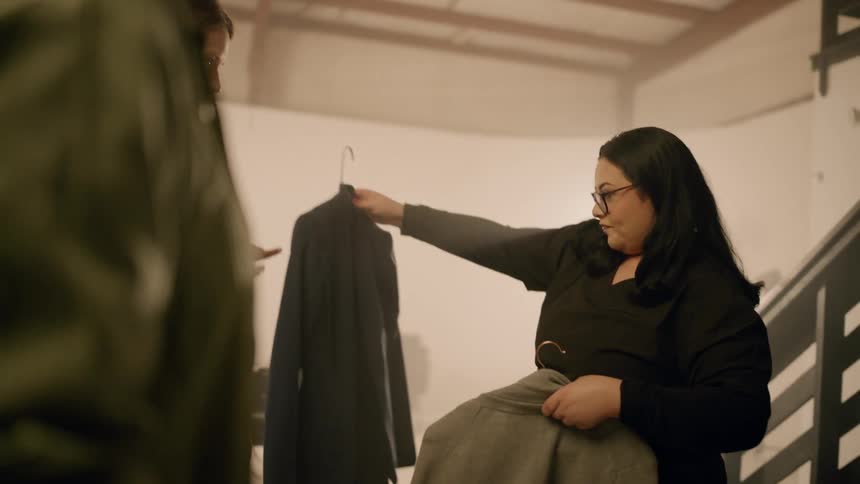 A woman is showing off different pieces of clothing
