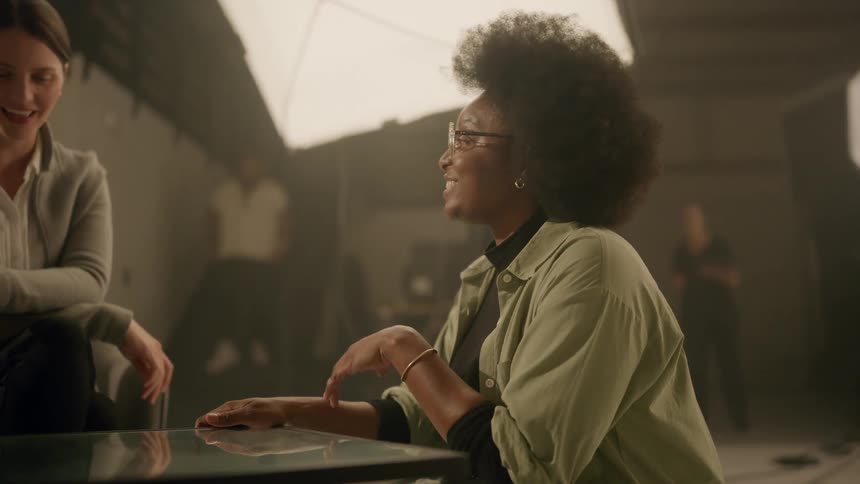 Two women sitting in a studio talking to each other