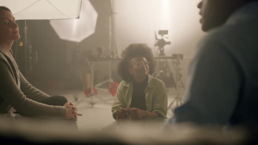 Three people sit in a studio and have a discussion