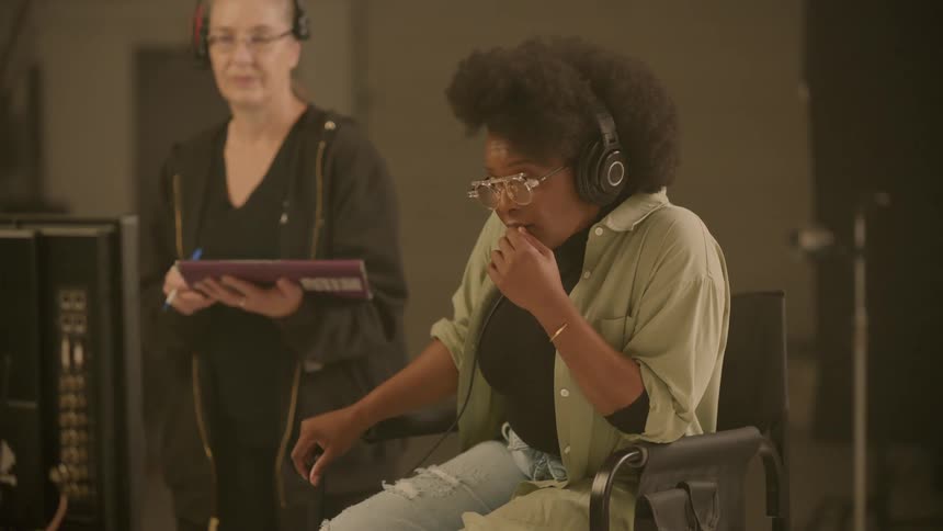 Woman sitting indoors with headphones on