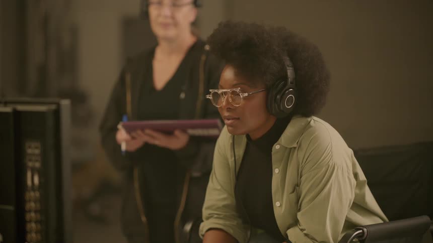 Two women look at a monitor together in the studio