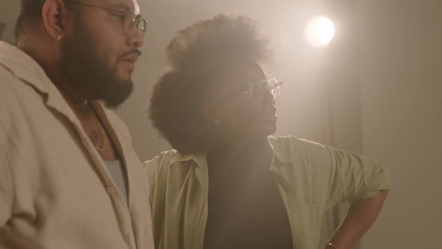 A clip of a male and female having a conversation in a studio room