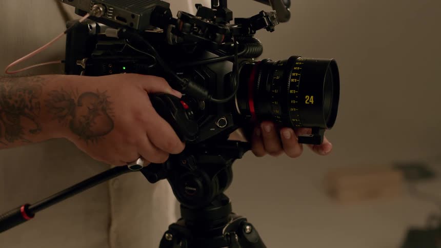 A person is holding a camera adjusting the zoom