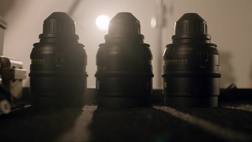 Three black camera lenses sitting on a table