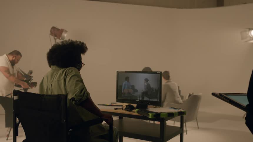A director watches two actors in a scene