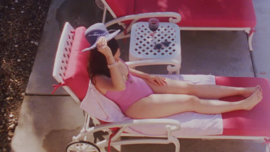 A woman sunbathing takes her hat off