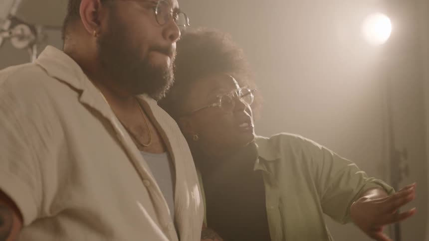 Female director talking to a man and making hand gestures inside a studio