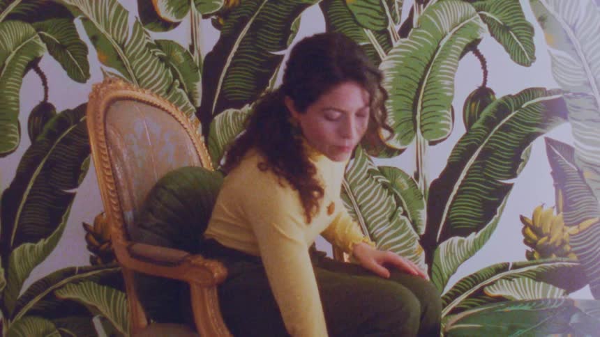 Woman sitting on a chair and taking high heels off her feet