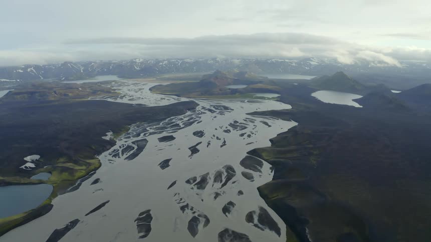 Aerial view of a braided glacial river and icelandic landscape with low hanging clouds
