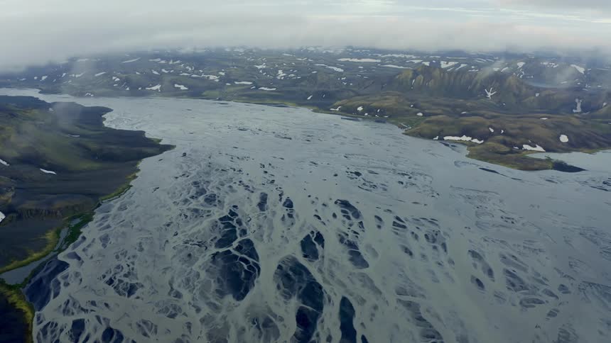 Aerial panorama of a frozen lake and mountains with snow around