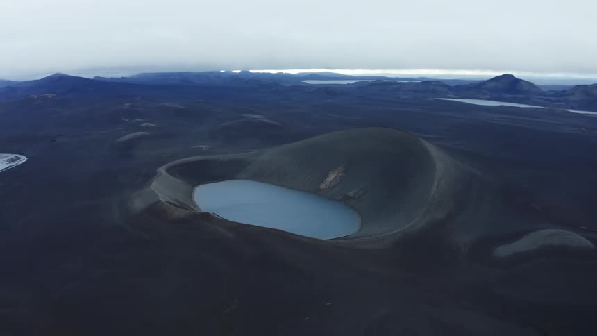 Volcanic crater lake under an overcast sky