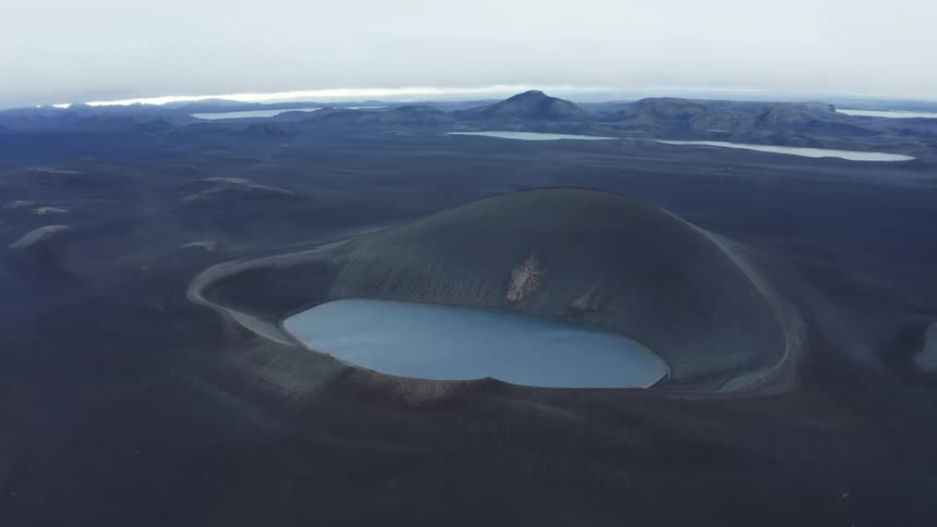 An aerial view of a circular lake in a volcanic crater