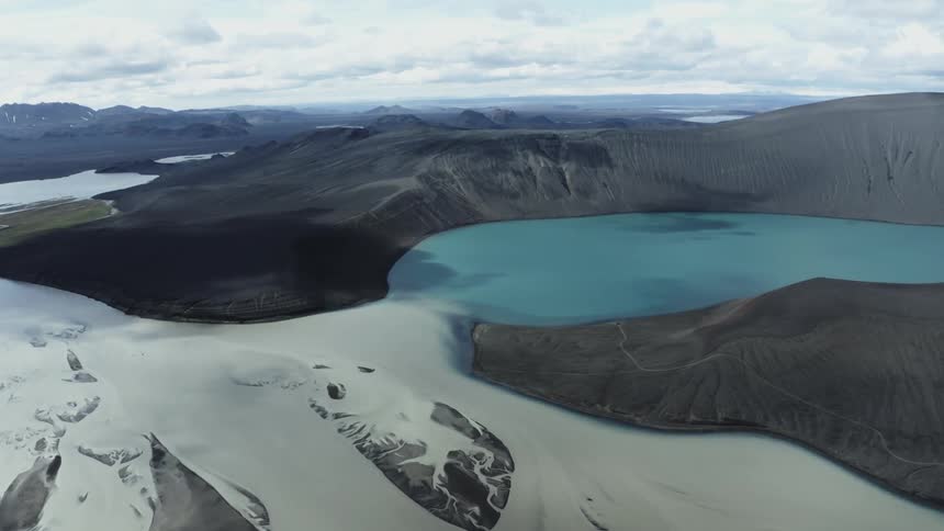 A glacier sits next to a volcano crater filled with water