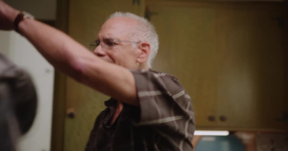 A man and woman dance in a kitchen