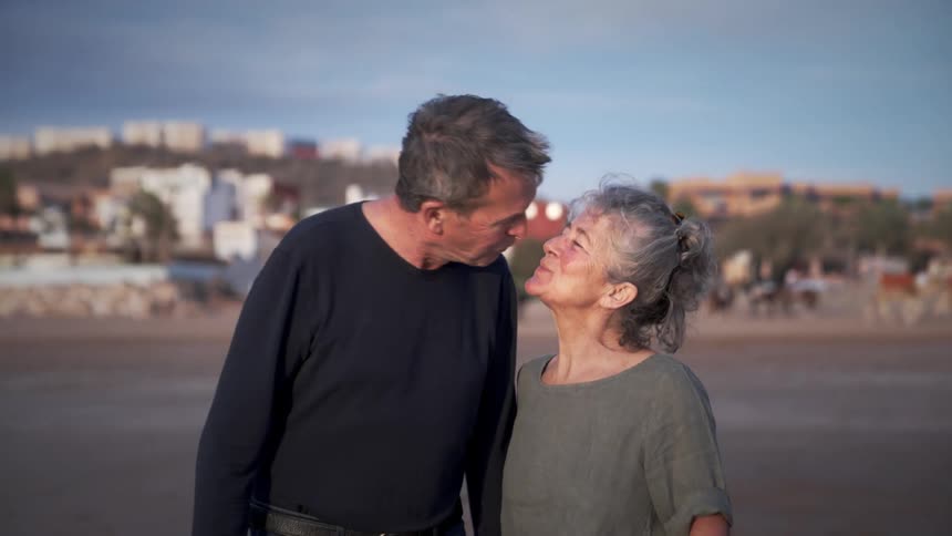 An happy older couple holding hands and kissing