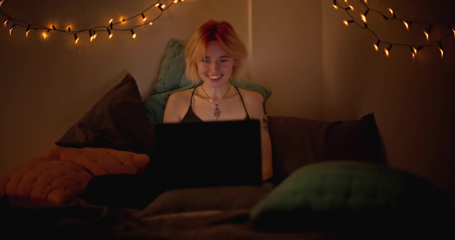 Female is laughing and smiling while browsing on a laptop