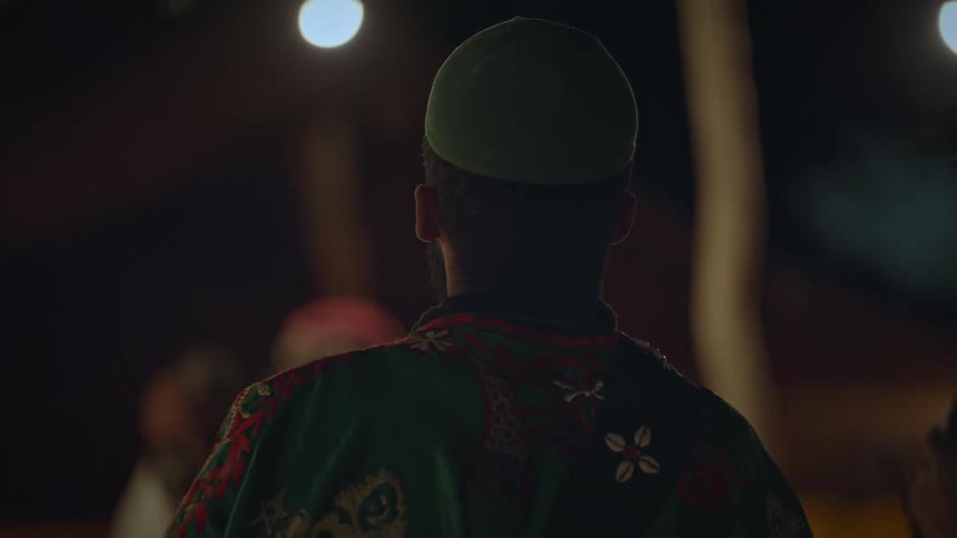 A man watches people dancing to music