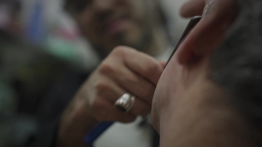 Barber shaving a man with a razor