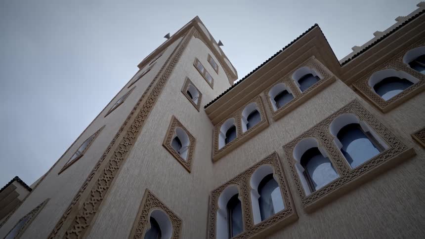 Upward view of one time exterior architecture with vintage windows on a cloudy day