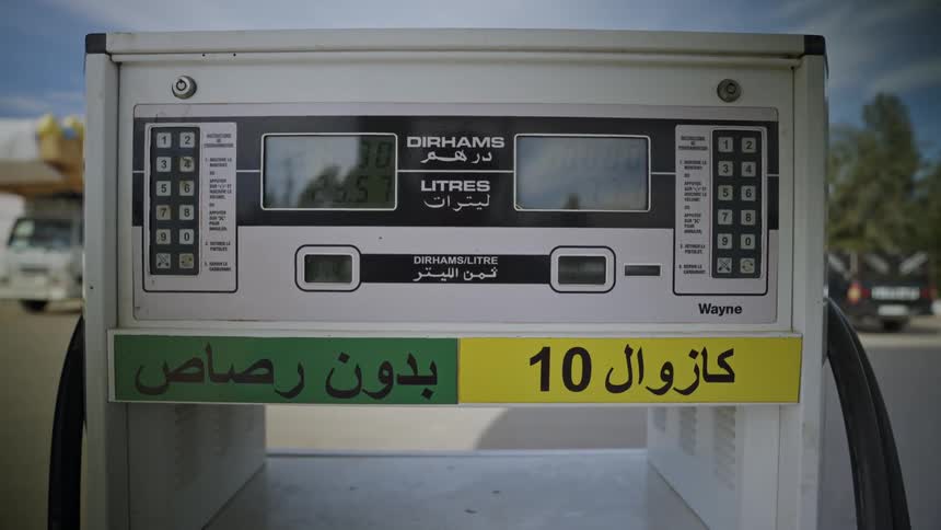 Close up of a gas station pump showing prices in dinars