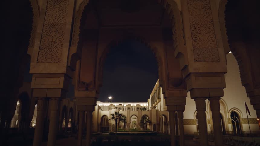 An imposing structure with huge arches near another building