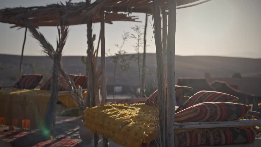 A clip of a couch and pillows under a shade in a rural community