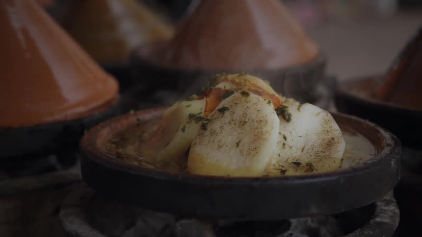 A clip of a person cooking on a hot pot and covering it with a cone
