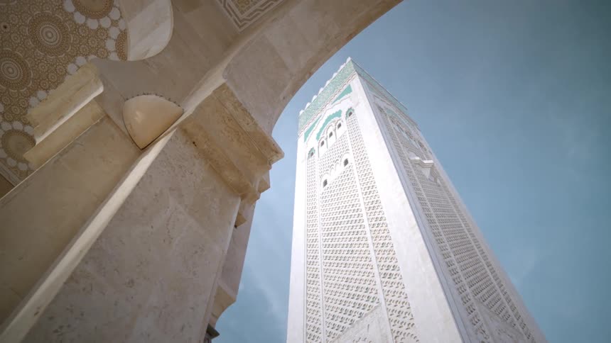 A tall church tower on a sunny day with minimal clouds hassan mosque