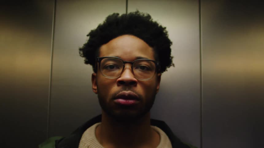 A black man opens his eyes in an elevator and leaves