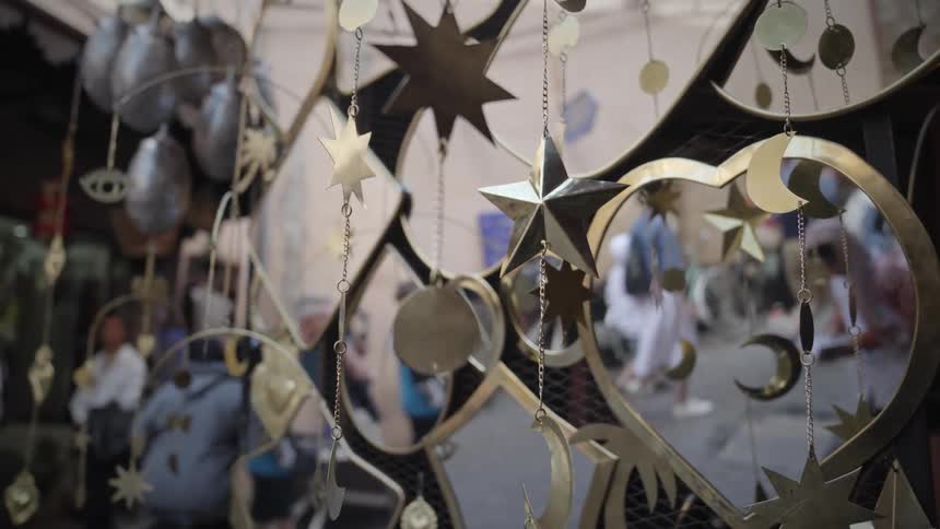 Golden mirrors and decorative objects for sale in a store on a busy street