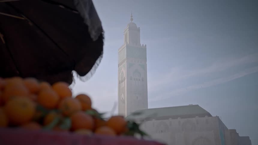 Grocery store with oranges for sale and a view of a temple tower