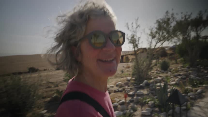 Portrait of a woman hiking in a natural environment through the desert with a happy facial expression