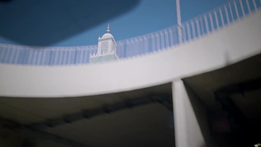 View from inside a moving car passing through a tunnel with a view of a temple tower