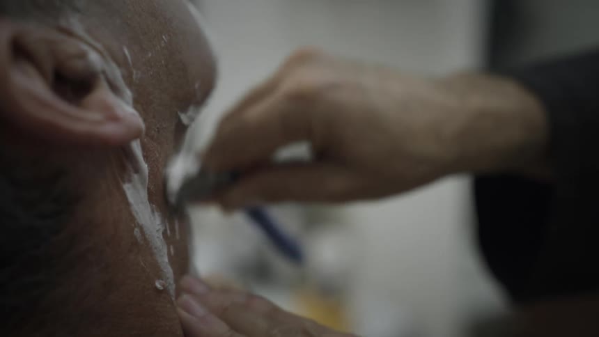 Man is getting shaved at a barber shop