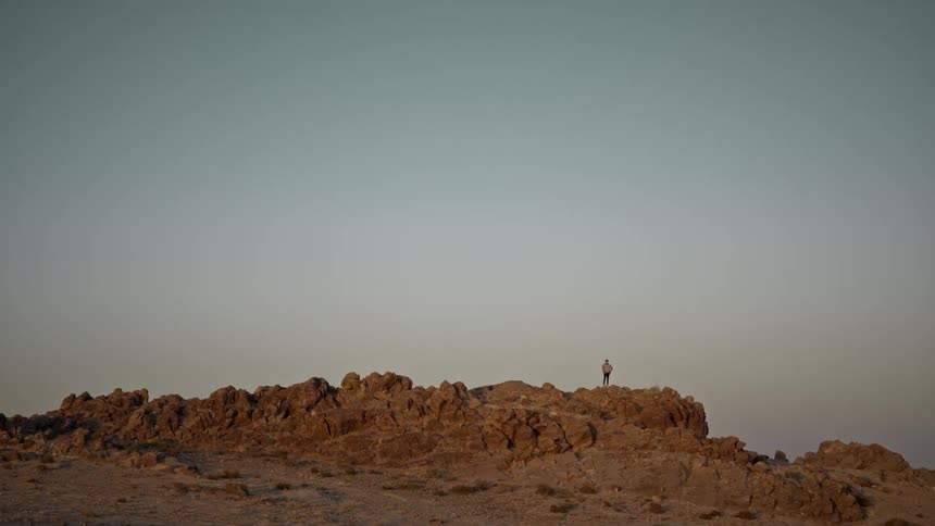A person is hiking through the desert by themselves