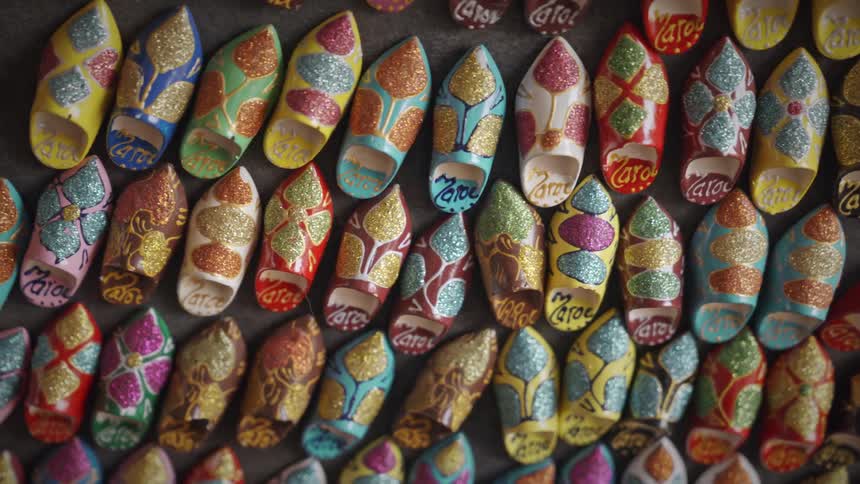 Rows of painted moroccan souvenir slippers laying on the floor