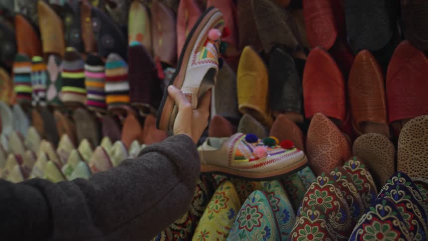 Womans hand looking at handmade shoes