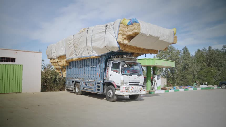 Truck with load of dry straw parked at a gas station