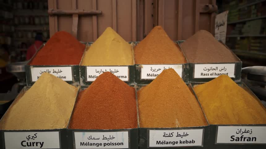 Eight separate bins have piles of different spices in them