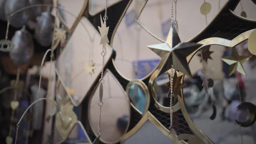 Middle eastern people reflected on mirrors hanging from a store