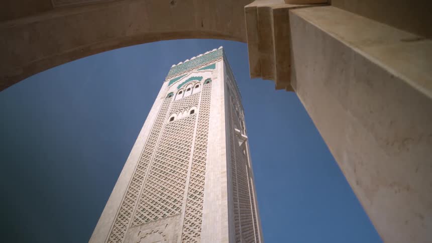 The tower of hassan ii mosque under a blue sky