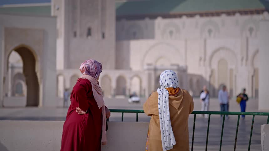 A clip of two women standing beside a barricade