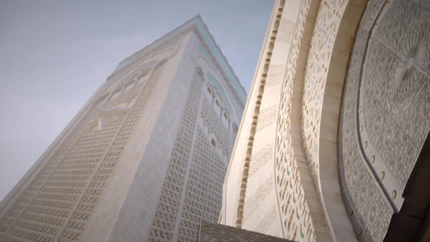 Ornate facade of tower at the mosque in casablanca from a ground perspective