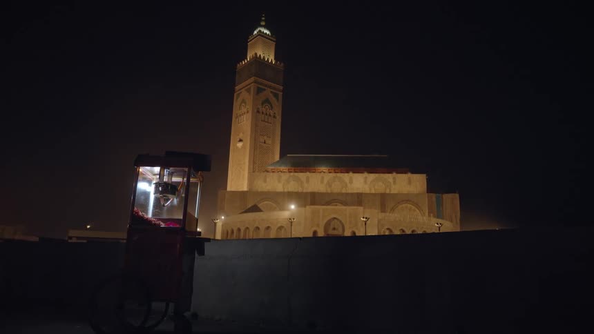 View of a popcorn cart on the edge of a temple with a tower at night