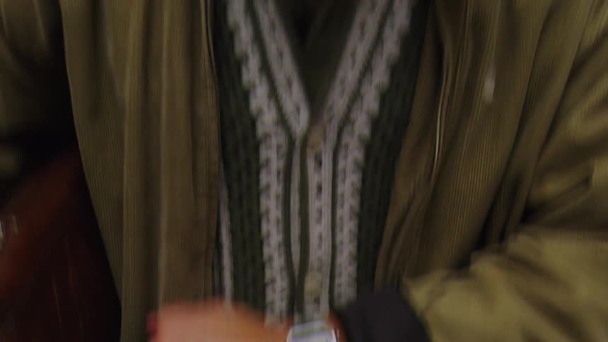Man is waiting in an elevator and checks his wristwatch