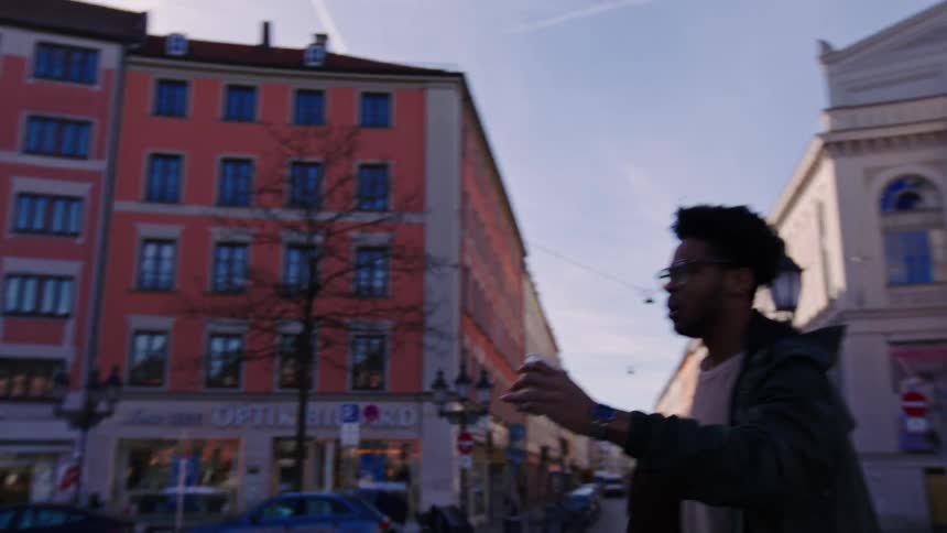 Man running in a square holding a coffee and then walking again